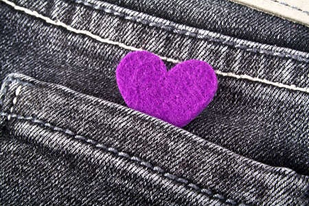 Purple heart in black jeans pocketの写真素材