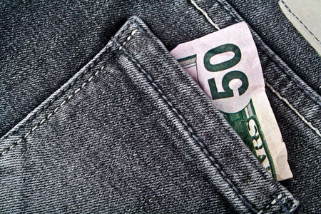 Fifty American dollars bill sticking out of the back jeans pocketの写真素材