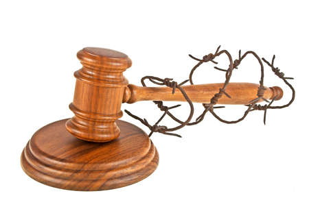 Wooden judge gavel and barbed wire on a white backgroundの写真素材