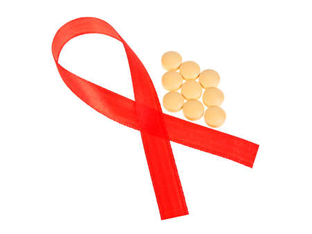 Red AIDS Awareness Ribbon and Pills. AIDS awareness ribbon on white background.の写真素材
