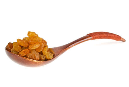 Yellow raisins in wooden spoon on a white backgroundの写真素材