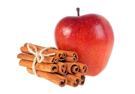 Red apple and cinnamon sticks on a white backgroundの写真素材