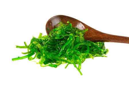Japanese Cuisine - Chuka Seaweed Salad with sesame seeds in wooden spoon on a white background. Close up.の写真素材