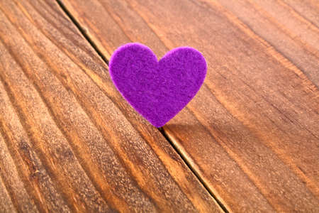 Violet heart on a wooden background. Valentines day.の写真素材