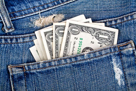 American dollars sticking out of the blue jeans pocket