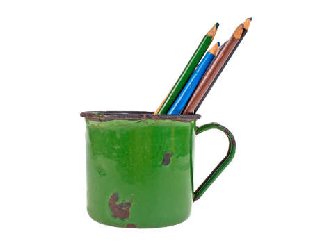Old cup green color and pencils on white backgroundの写真素材