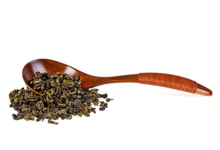 Green tea leaves and wooden spoon isolated on white backgroundの写真素材