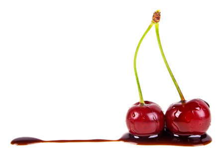 Two cherries in chocolate on a white backgroundの写真素材