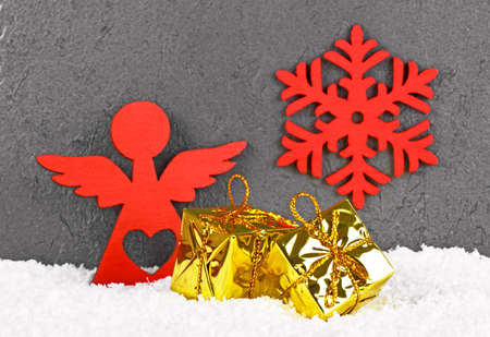 Christmas golden boxes, red angel and snowflake in the snow. Christmas greeting card.の写真素材