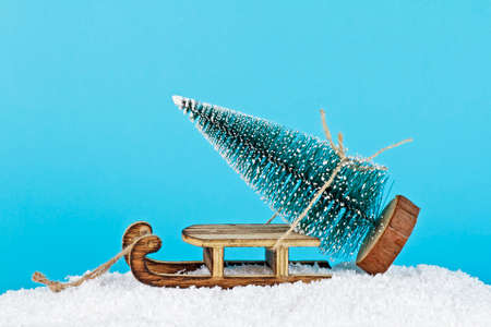 Christmas composition. Wooden sleigh and Christmas tree on a blue background.の写真素材