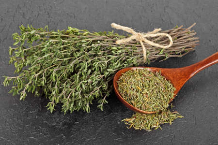 Dried thyme and bundle of thyme sprigs on black backgroundの写真素材