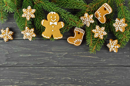 Christmas background on wooden boards. Gingerbread and Christmas tree branches.の写真素材