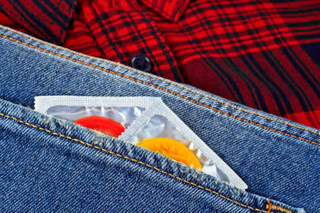 Colored condoms in jeans pocketの写真素材