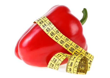 Red sweet bell pepper and measuring tape on a white background. Healthy food and diet concept.の写真素材