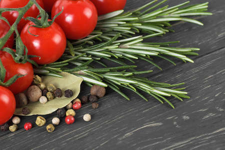 Cherry tomatoes, herbs and spices on wooden backgroundの写真素材