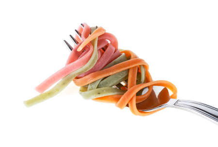 Colorful pasta tagliatelle on fork, white backgroundの写真素材