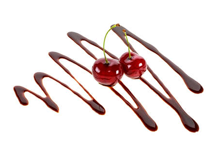 Two cherries in liquid chocolate on a white backgroundの写真素材
