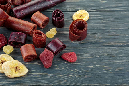 Fruit pastille and dried fruits on wooden boardの写真素材