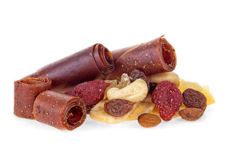 Fruit pastille and heap of dried fruits, seeds and nuts. White background. Concept of healthy food.