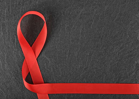 Healthcare and medicine concept - red AIDS awareness ribbon on black background.の写真素材