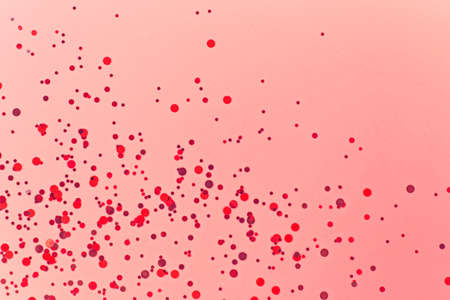 Pastel background with red confetti, copy space. Festive background. Holiday frame.の写真素材