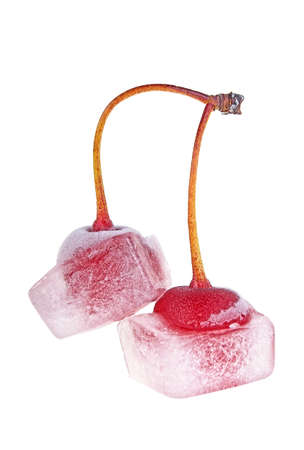 Frozen cherries. Two cherries in ice cubes isolated on a white background. Ice cubes in cocktail cherries.の写真素材