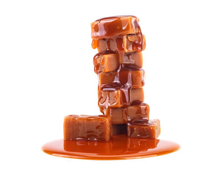 Caramel candies with caramel sauce isolated on a white backgroundの写真素材