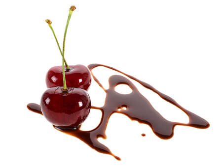 Two ripe cherries in chocolate isolated on a white backgroundの写真素材