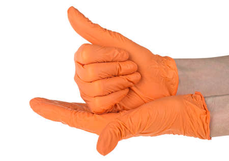 Hands of a medic wearing a orange latex gloves. Medical gloves. Surgical glove. Covid-19 prevention concept.の写真素材