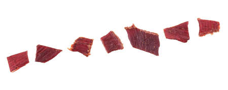 Pieces of beef jerky isolated on white background, top view. Cured meat. Dried meat.の写真素材