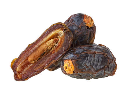 Big dried date fruits isolated on a white background. Three date fruits, whole and half.の写真素材