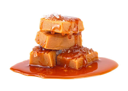 Delicious candies with caramel sauce and salt isolated on a white background. Melted caramel candies with sea salt.の写真素材