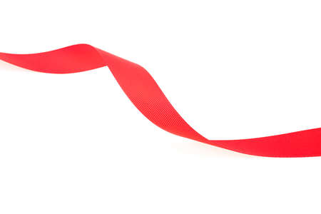 Red silk ribbon isolated on a white background, close up. Extending simple red ribbon. Red satin ribbon.の写真素材