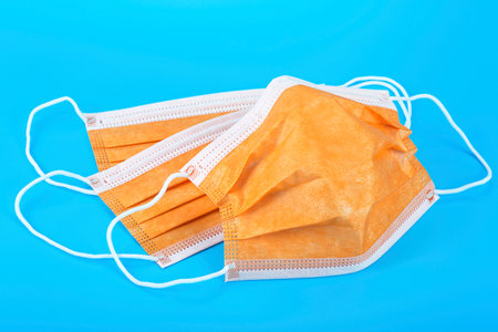 Protection concept - Colorful medical masks on blue background. Surgical mask with rubber ear straps.の写真素材