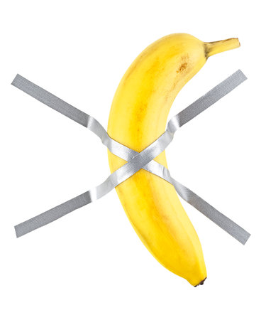 Banana duct taped to the white wall. Yellow sweet banana on the wall.の写真素材