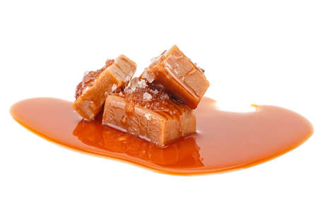 Salted toffee candies with caramel sauce isolated on a white background. Salted caramel pieces. Golden Butterscotch toffee caramels.の写真素材