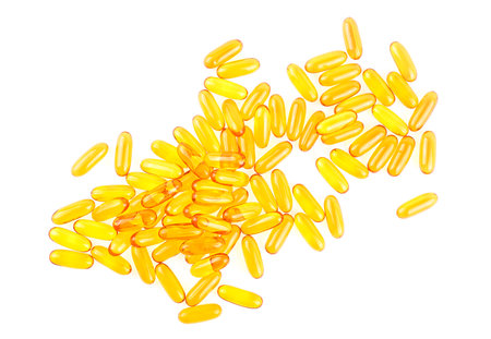 Omega 3 capsules isolated on a white background, top view. Fish oil yellow softgels. Vitamin D, E, A.の写真素材