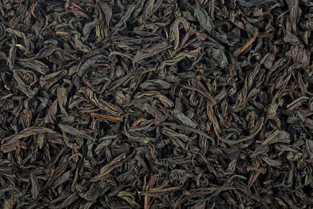 Background texture of dried black tea leaves. Chinese tea. Large dry leaves of black tea.の写真素材