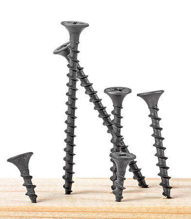 Wood black screws on a wooden background, isolated image.の写真素材