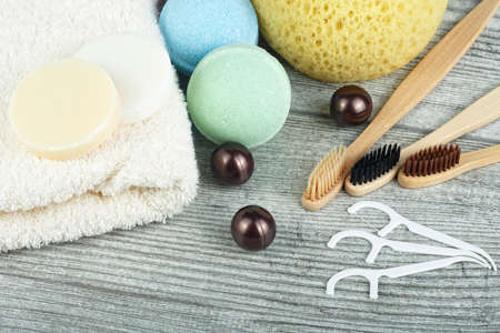 Dental and body care on wooden background, close up. Bamboo toothbrushes, washcloth, toothpicks,...