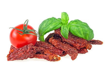 Delicious dried tomatoes and fresh basil isolated on a white background. Sun dried tomatoes.の写真素材