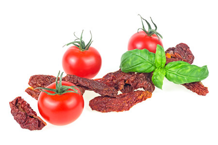 Delicious dried tomatoes and fresh basil isolated on a white background. Sun dried tomatoes.の写真素材