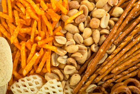 Range of salty snacks, as background. Pretzels, potato chips, crackers and salty straw.の写真素材