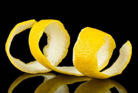 Lemon peel or lemon twist on a black background. Lemon slice as cocktail ingredient.の写真素材