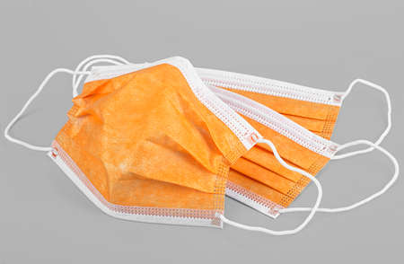 Protection concept - Colorful medical masks on gray background. Surgical mask with rubber ear straps.の写真素材