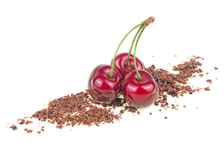 Three red cherries in chocolate dipped with grated chocolate isolated on a white backgroundの写真素材