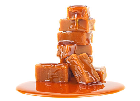 Delicious sweets with caramel sauce isolated on a white background. Candies with caramel topping.の写真素材
