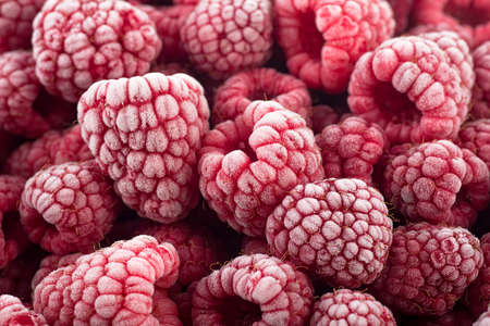 Berries background - Frozen raspberries covered with hoarfrost. Summer berries, top view.