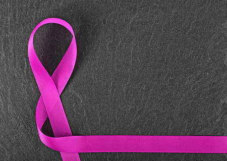 Violet awareness ribbon on black background, symbol of disease control.の写真素材