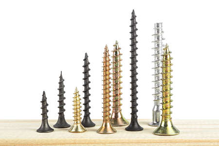 Industry concept - black and golden screws on wooden board isolated on a white background.の写真素材